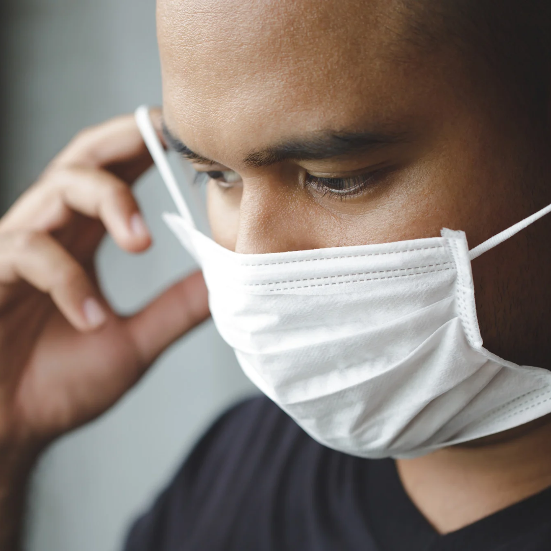 Close-up of man putting on mask